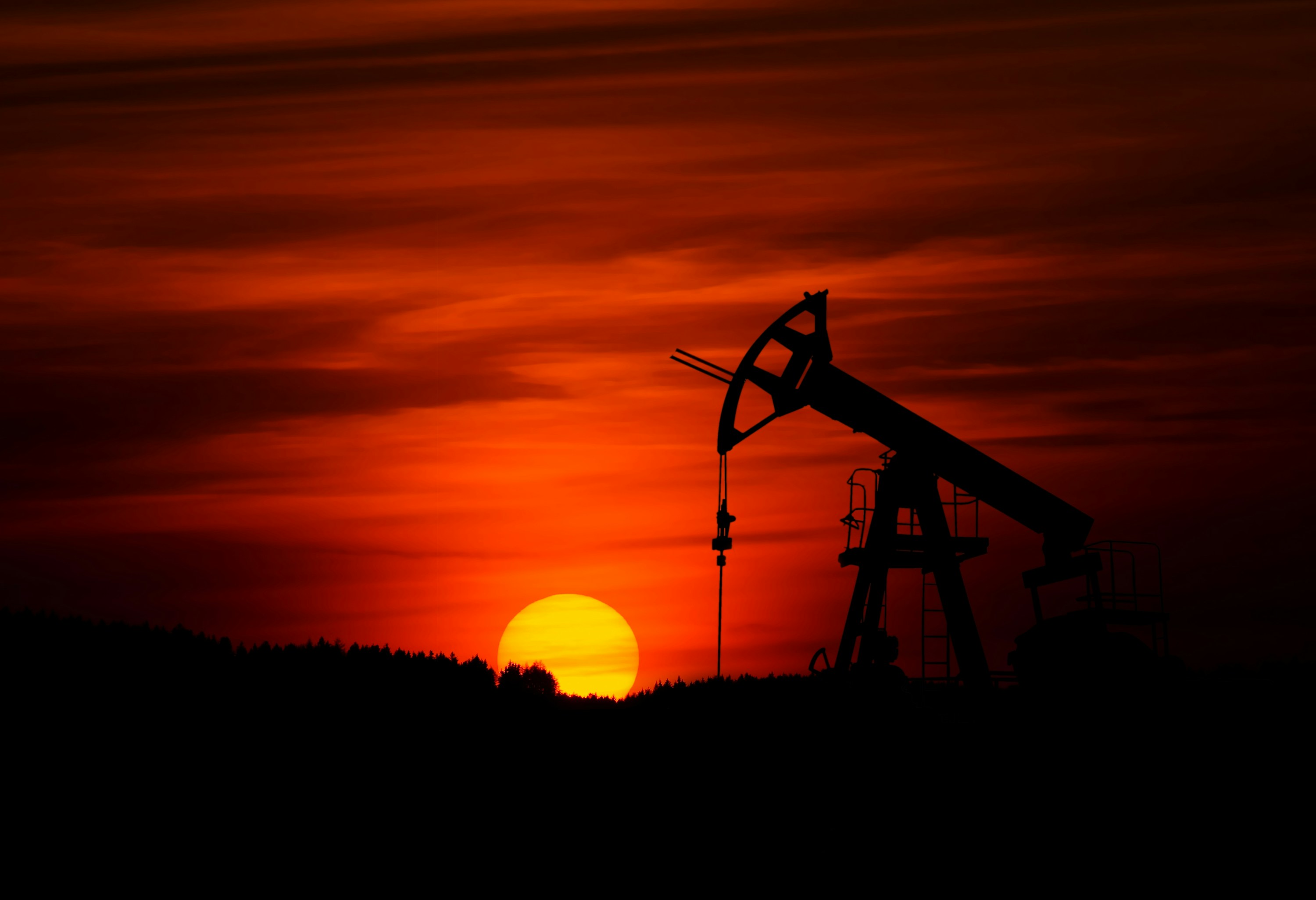 Oil pumpjack silhouetted against an evening sky